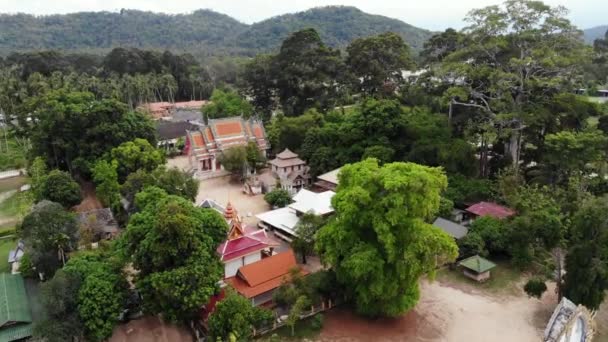 Klasyczna buddyjska świątynia pomiędzy lasami. Z góry dron widok klasyczny klasztor buddyjski między zielonymi drzewami w pobliżu wzgórza w Tajlandii. Koh Samui. koncepcja turystyki, medytacji i orientalnego życia — Wideo stockowe