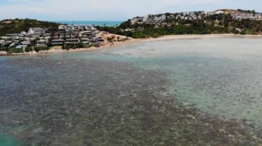 Okyanusta evleri olan yeşil bir ada. Tayland 'daki güzel Ko Samui adasının güneşli bir günde turkuaz suyla çevrili insansız hava aracı manzarası..