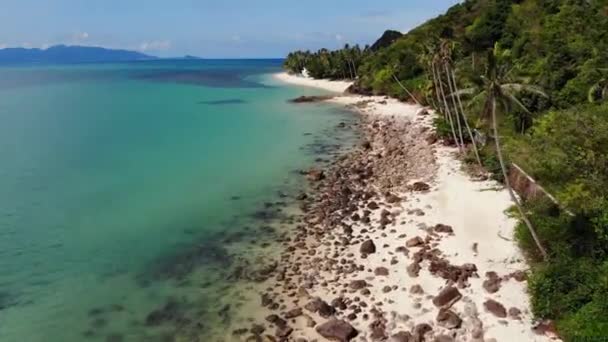 Selva verde y playa pedregosa cerca del mar. Selva tropical y rocas cerca del tranquilo mar azul en la costa de arena blanca de la isla paradisíaca de Koh Samui, Tailandia. Vista de drones de playa de ensueño. Relax y concepto de vacaciones. — Vídeo de stock