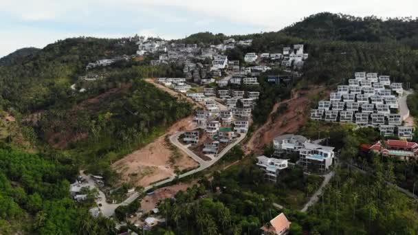 Teren tropikalny pokryty zagrożonymi lasami i luksusowymi willami. Drone widok dużych tropików z zaburzeniami ekosystemu z powodu budynków i wylesiania. Koh Samui. Plantacje palm kokosowych. — Wideo stockowe