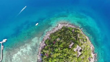 Küçük tropikal volkanik ada Koh Tao yakınlarındaki sakin, masmavi turkuaz deniz, eşsiz küçük cennet Nang Yuan. Güneşli Tayland 'da güneşli bir günde taşlık sahil ve yeşil ormanın yakınındaki huzurlu suyun insansız hava aracı görüntüsü.