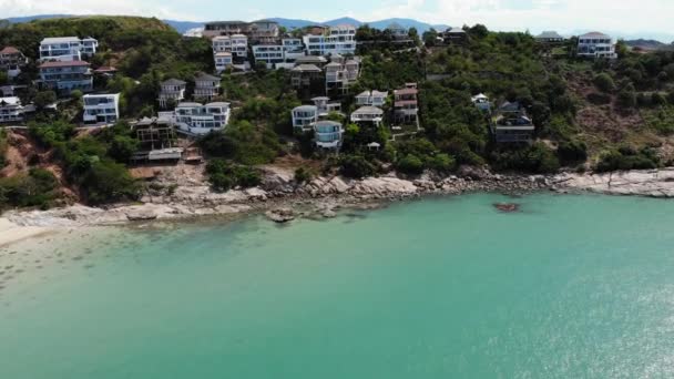 海に家がある緑の島。晴れた日にはターコイズブルーの水に囲まれたタイの美しいサムイ島のドローンビュー. — ストック動画