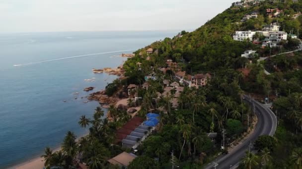 Villas en la cordillera verde. Majestuosas vistas al dron de villas de lujo ubicadas en la cordillera verde en la isla tropical paradisíaca cerca de la pequeña playa. Orilla pedregosa y selva verde de Koh Samui volcánico — Vídeo de stock