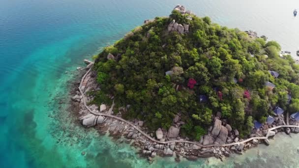 Küçük tropikal volkanik ada Koh Tao yakınlarındaki sakin, masmavi turkuaz deniz, eşsiz küçük cennet Nang Yuan. Güneşli Tayland 'da güneşli bir günde taşlık sahil ve yeşil ormanın yakınındaki huzurlu suyun insansız hava aracı görüntüsü. — Stok video