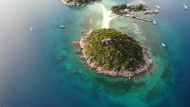 Küçük tropikal volkanik ada Koh Tao yakınlarındaki sakin, masmavi turkuaz deniz, eşsiz küçük cennet Nang Yuan. Güneşli Tayland 'da güneşli bir günde taşlık sahil ve yeşil ormanın yakınındaki huzurlu suyun insansız hava aracı görüntüsü.