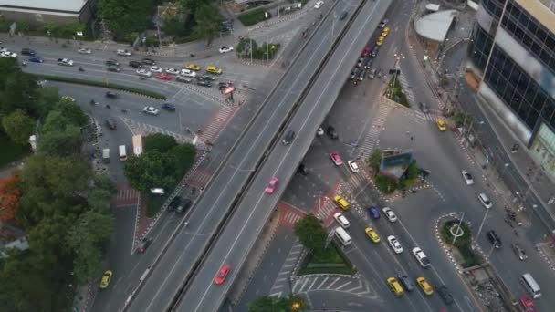 Verkehr auf der Kreuzung auf der Straße. Von oben fahren moderne Autos und Motorräder auf einer Straßenkreuzung im Zentrum von Bangkok, Thailand — Stockvideo