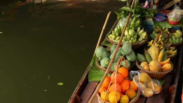 Рынок плавучих товаров Iconic Fabric Lat Mayom. Клонг речной канал, длиннохвостая лодка с тропическими экзотическими красочными фруктами, органические местные овощи. Вид сверху на уборочную и уличную еду в деревянном каноэ — стоковое видео