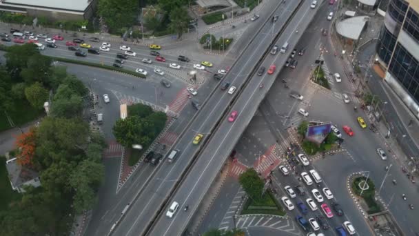 Verkehr auf der Kreuzung auf der Straße. Von oben fahren moderne Autos und Motorräder auf einer Straßenkreuzung im Zentrum von Bangkok, Thailand — Stockvideo