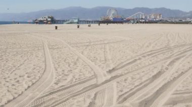 Okyanus dalgaları ve kumlu California plajı Santa Monica Pasifik Okyanusu 'ndaki rıhtımdaki eğlence parkında klasik dönme dolap. Yazın ikonik manzara, Los Angeles 'ın sembolü, CA USA. Seyahat kavramı