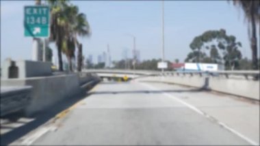 Los Angeles, Kaliforniya 'da şehirlerarası otobanda araba sürüyorum. Yoğun otoyoldaki arabanın cam ön camından odaklanmış görüntüsü. Bulanık banliyö yolu. Kamera Los Angeles 'ta.