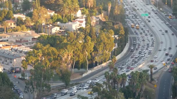 Drukke spitsuur intercity snelweg in Metropolis, Los Angeles, Californië, USA. Stedelijke file op de weg in het zonlicht. Luchtfoto van auto 's op meerbaans oprit. Snelweg met auto 's in Los Angeles — Stockvideo