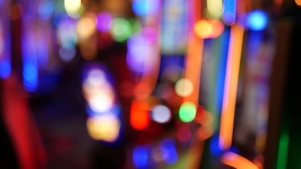 Defocused slot machines glow in casino on fabulous Las Vegas Strip, USA. Blurred gambling jackpot slots in hotel near Fremont street. Illuminated neon fruit machine for risk money playing and betting — Stock Video