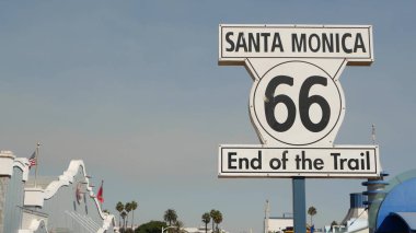 Santa Monica, LOS ANGELES, ABD - 28 OCT 2019: 66. tarihi güzergah, ünlü klasik Kaliforniya gezi sembolü. Pasifik Okyanusu kıyısındaki tatil köyünde. Lunaparkta mavi gökyüzüne karşı ikonik retro yol işareti.