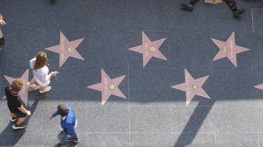 LOS ANGELES, CALIFORNIA, ABD - 7 NOV 2019: Los Angeles Hollywood Bulvarı 'nda şöhret yürüyüşü. Asfalt üzerinde ünlü yıldızların yanında yürüyen pedastrianlar. Dolby ve TCL Çin Tiyatrosu yakınlarındaki yürüyüş pisti..