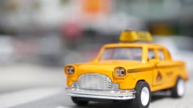 Sarı, boş, mini taksi, Harmon köşesi, Las Vegas, ABD. Odaklanamayan arka planda küçük bir eski araba modeli. Yumuşak odak noktasında ulaşım sembolü olarak küçük ikonik otomobil oyuncağı. Bulanık alışveriş merkezi