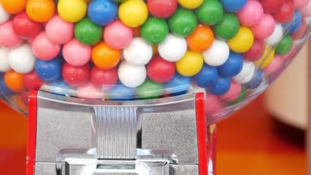 Kleurrijke kauwgomballen in klassieke automaat, USA. Multi gekleurde buble tandvlees, munt bediende retro dispenser. Kauwgom snoepjes als symbool van kindertijd en zomertijd. Gemengde zoetigheden in vintage automatiseren — Stockvideo