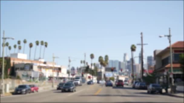 Mengemudi di jalanan pusat kota Los Angeles, California USA. Pemandangan yang tidak fokus dari kaca kaca mobil di jalan masuk. Jalan kabur dengan kendaraan di Hollywood. Kamera di dalam auto, LA kota estetika — Stok Video