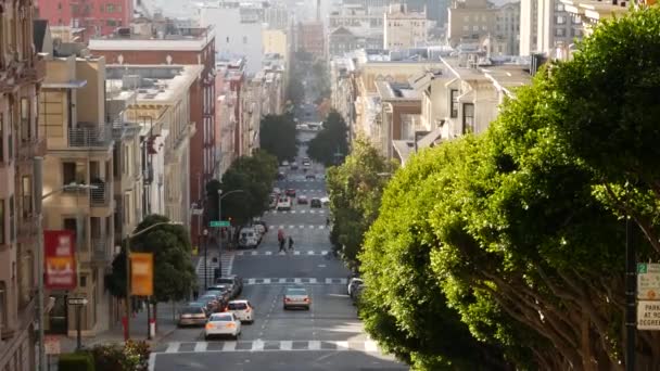 Iconische heuvelachtige straat en kruispunt in San Francisco, Noord-Californië, Verenigde Staten. Steile afdaling weg en voetgangers loopbrug. Downtown onroerend goed, victoriaanse herenhuizen en andere residentiële gebouwen — Stockvideo