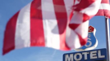 Tarihi güzergah 66 'daki motelin retro tabelası Amerika' nın klasik yol gezisi sembolü. Arizona çölünde ikonik pano. Eski moda neon tabela. Ulusal bayrak dalgalanması