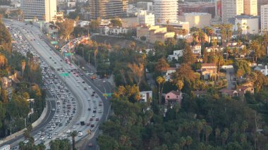Metropolis, Los Angeles, Kaliforniya 'da yoğun trafik saatleri var. Gün ışığında şehir trafiği sıkışık. Birden fazla şeritteki arabaların hava görüntüsü. Los Angeles 'ta otomobilli otoban.