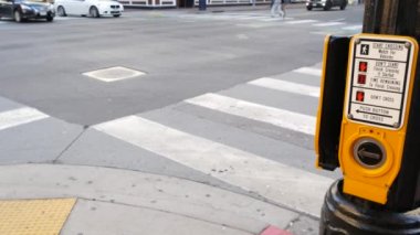Yaya geçidinde trafik ışığı düğmesi, insanlar itmek ve beklemek zorunda. ABD 'de halkın güvenliği için trafik kuralları ve yönetmelikleri. Zebra caddesi San Diego, Kaliforniya 'da yol ayrımında kesişiyor.