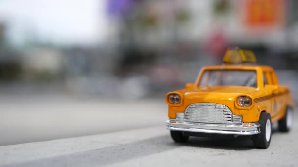 Žlutý volný mini taxi taxi zblízka, Harmon rohu, Las Vegas, USA. Malý retro model auta na rozostřeném pozadí. Malá kultovní autohračka jako symbol dopravy v měkkém ostření. Rozmazané nákupní centrum — Stock video