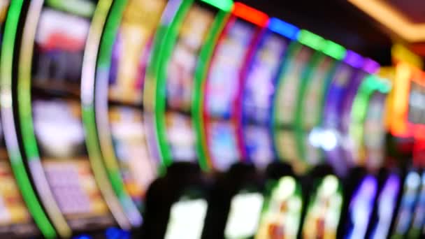 Defocused slot machines glow in casino on fabulous Las Vegas Strip, USA. Blurred gambling jackpot slots in hotel near Fremont street. Illuminated neon fruit machine for risk money playing and betting — Stock Video