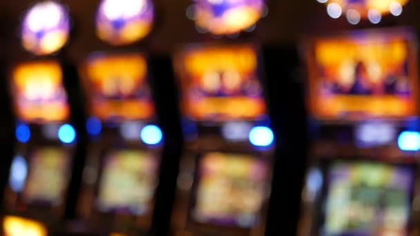 Defocused slot machines glow in casino on fabulous Las Vegas Strip, USA. Blurred gambling jackpot slots in hotel near Fremont street. Illuminated neon fruit machine for risk money playing and betting — Stock Video