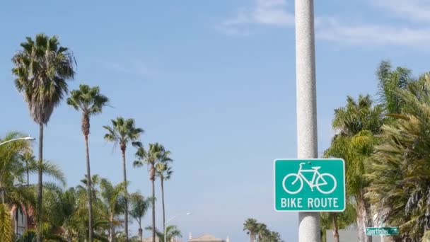Bike Route cartello stradale verde in California, USA. Pista ciclabile singpost. Pista ciclabile in Oceanside pacifico località turistica. Cartello ciclabile e palmo. Stile di vita sano, ricreazione e simbolo della sicurezza ciclistica — Video Stock