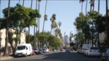 Los Angeles, Kaliforniya 'nın şehir merkezindeki caddelerde araba sürüyorum. Garaj yolundaki arabanın ön camından odaklı olmayan görüntü. Hollywood 'da araçları olan bulanık bir yol. Kamera otomobilin içinde, LA şehri estetiği.