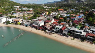 Deniz kıyısındaki balıkçı köyü. Güneşli bir günde Ko Samui adasında hediyelik eşya dükkanları ve caddeleri olan tipik turistik bir yerin havadan görünüşü. Asya 'da mimari, yerel yerleşim insansız hava aracı görüşü.