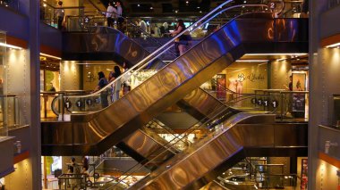 BANGKOK, THAILAND - 18 ARALIK, 2018: Siyam Paragon AVM AVM iç mimarisi. Ticaret merkezinin yürüyen merdivenlerinde bir sürü insan var. İnsanlar modern plazada alışverişe koşuyorlar. Mal tüketimi.