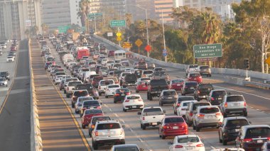 SAN DIEGO, CALIFORNIA USA - 15 HAZİRAN 2020: yoğun şehirlerarası otoyol, yoğun saatlerde otoyolda trafik sıkışıklığı. Şehir silüeti ve gökdelenler. Metropolis 'te ulaşım kavramı ve taşımacılık.