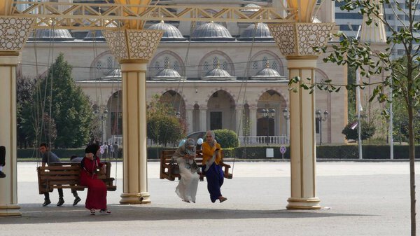 ГРОЗНЫЙ, ЧЕШЕНСКАЯ РЕСПУБЛИКА ОФ ИЧКЕРИЯ, КАВКАЗ, РОССИЯ, 6 СЕНТЯБРЯ 2019 года День гражданского согласия и единства "Сердце Чечни". Счастливые молодые люди, радостные мусульмане мужчины и женщины веселятся на качелях