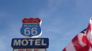 Tarihi güzergah 66 'daki motelin retro tabelası Amerika' nın klasik yol gezisi sembolü. Arizona çölünde ikonik pano. Eski moda neon tabela. Ulusal bayrak dalgalanması
