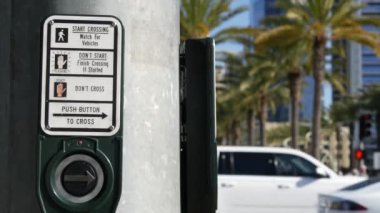 Yaya geçidinde trafik ışığı düğmesi, insanlar itmek ve beklemek zorunda. ABD 'de halkın güvenliği için trafik kuralları ve yönetmelikleri. Zebra caddesi San Diego, Kaliforniya 'da yol ayrımında kesişiyor.