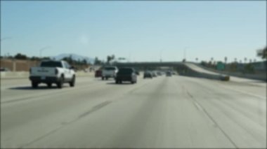 Los Angeles, Kaliforniya 'da şehirlerarası otobanda araba sürüyorum. Yoğun otoyoldaki arabanın cam ön camından odaklanmış görüntüsü. Bulanık banliyö yolu. Kamera Los Angeles 'ta.