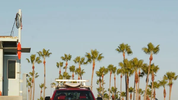 象徴的なレトロな木製のライフガードの時計塔 バイウォッチ赤い車 青い空に対する生活ブイ アメリカの国旗とヤシの木 カリフォルニアの夏の美しさ サンタモニカビーチ ロサンゼルス Usa — ストック写真