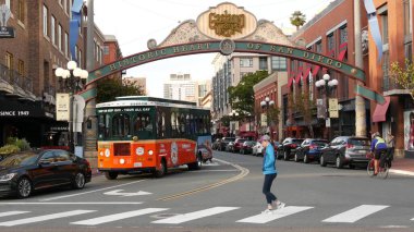 SAN DIEGO, CALIFORNIA USA - 30 HAZİRAN 2020: 5. Cadde 'deki Gaslamp Quarter tarihi giriş işareti. Turuncu ikonik retro tramvay, atlama otobüsü ve turistik yer, Eski Şehir Turu..
