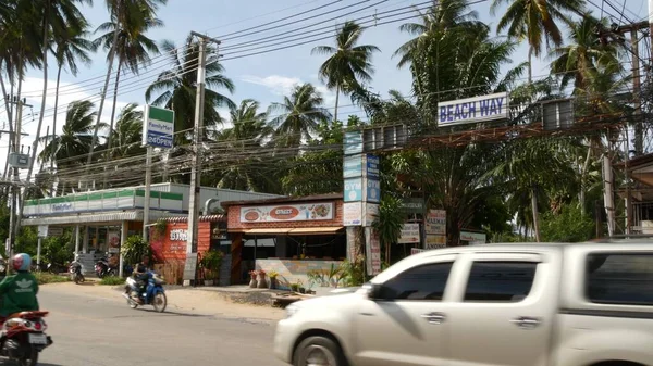 Koh Samui Island June 2019道端に車や小さなお店を運転しています ビーチウェイとチェーン店主要道路上のファミリーマート 典型的な観光村の通り バイクでタイ人 — ストック写真