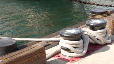 Metalik kazığa bağlanmış halatla yıldızlar, San Diego, California 'nın yelkenli limanı. Denizci gemisi rıhtıma demir attı. Rıhtımda kablo bağı kuruldu. Denizcilik ve donanma filosunun sembolü, ABD bayrağı.