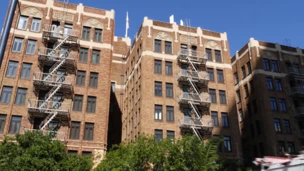 Fire escape ladder outside residential brick building in San Diego city, USA. Typical New York style emergency exit for safe evacuation. Classic retro house exterior as symbol of real estate property — Stock Video