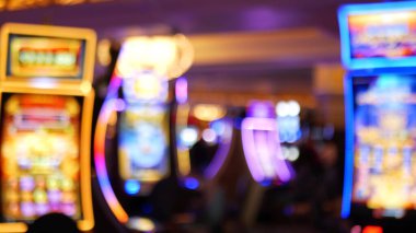 Defocused slot machines glow in casino on fabulous Las Vegas Strip, USA. Blurred gambling jackpot slots in hotel near Fremont street. Illuminated neon fruit machine for risk money playing and betting. clipart