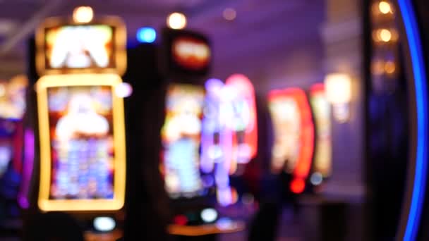 Defocused spilleautomater lyser på kasino på fantastiske Las Vegas Strip, USA. Tåkete spillejobber på hotell nær Fremont Street. Belyst neonfruktmaskin for risikopenger, spill og veddemål – stockvideo