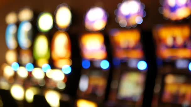 Las máquinas tragamonedas desenfocadas brillan en el casino en la fabulosa Las Vegas Strip, Estados Unidos. Desenfocado juego jackpot ranuras en el hotel cerca de la calle Fremont. Máquina de fruta de neón iluminada para jugar y apostar dinero de riesgo — Vídeos de Stock