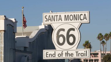 Santa Monica, LOS ANGELES, ABD - 28 OCT 2019: 66. tarihi güzergah, ünlü klasik Kaliforniya gezi sembolü. Pasifik Okyanusu kıyısındaki tatil köyünde. Lunaparkta mavi gökyüzüne karşı ikonik retro yol işareti.