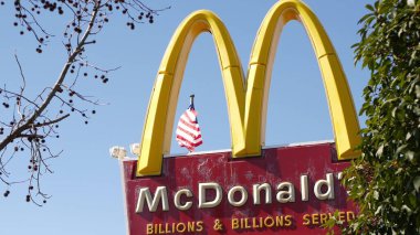 VİSTA, CALIFORNIA ABD - 16 Şubat 2020: McDonalds logosu ve Amerikan bayrağı. Sarı harfli M simgesi, Yıldızlar ve Çizgiler. Altın kemer amblemi, banliyö bölgesinde marka işareti. Sokaktaki yemek restoranı.