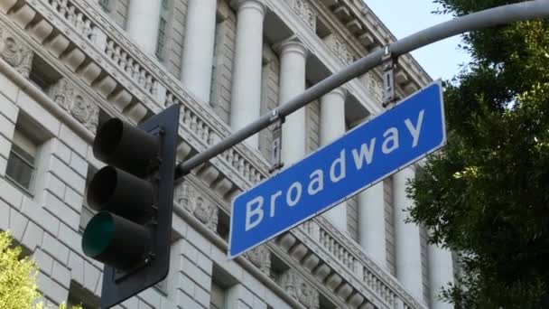 Broadway gadenavn, odonym tegn og trafiklys på søjle i USA. Vejkryds i centrum af byen. Crossroad i det centrale erhvervskvarter. Navneskilt banner med titel af vigtigste avenue – Stock-video