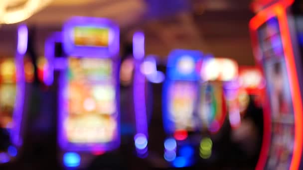 Defocused slot machines glow in casino on fabulous Las Vegas Strip, USA. Blurred gambling jackpot slots in hotel near Fremont street. Illuminated neon fruit machine for risk money playing and betting — Stock Video