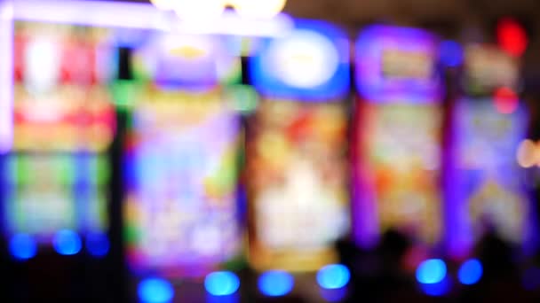 Defocused slot machines glow in casino on fabulous Las Vegas Strip, USA. Blurred gambling jackpot slots in hotel near Fremont street. Illuminated neon fruit machine for risk money playing and betting — Stock Video